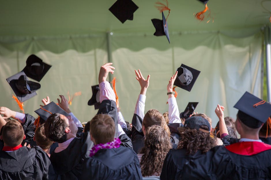 Group of graduates celebrating by tossing caps into the air during a graduation ceremony