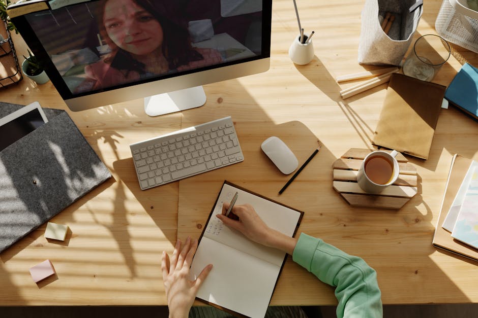 A student taking notes during a video call for online learning at home