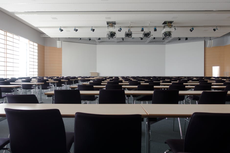 Spacious contemporary conference room with rows of tables and chairs