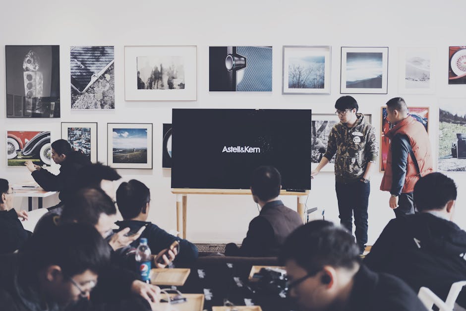 A group of adults attending a casual business presentation in a modern art space